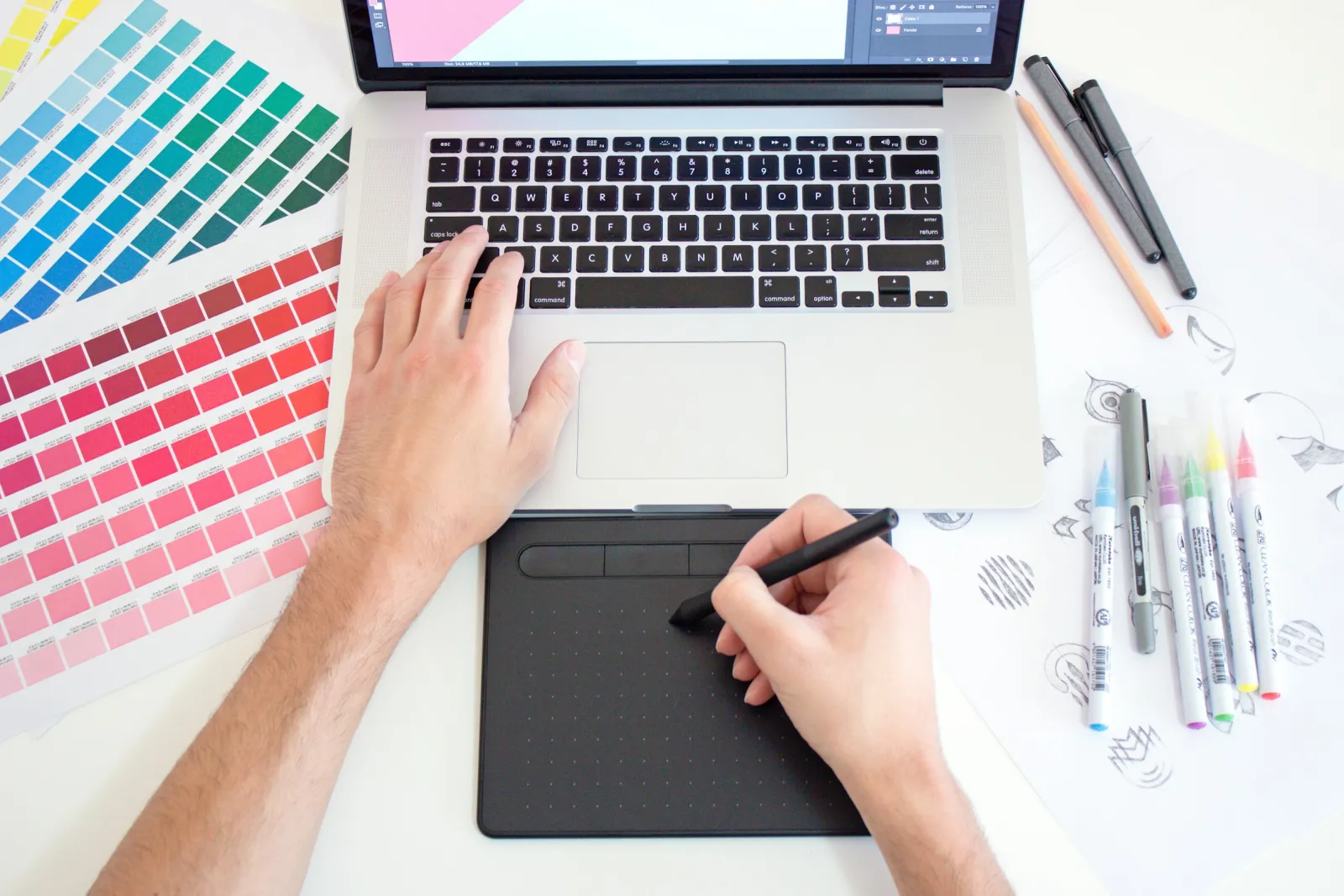A designer sketching and using colour swatches at a creative workspace
