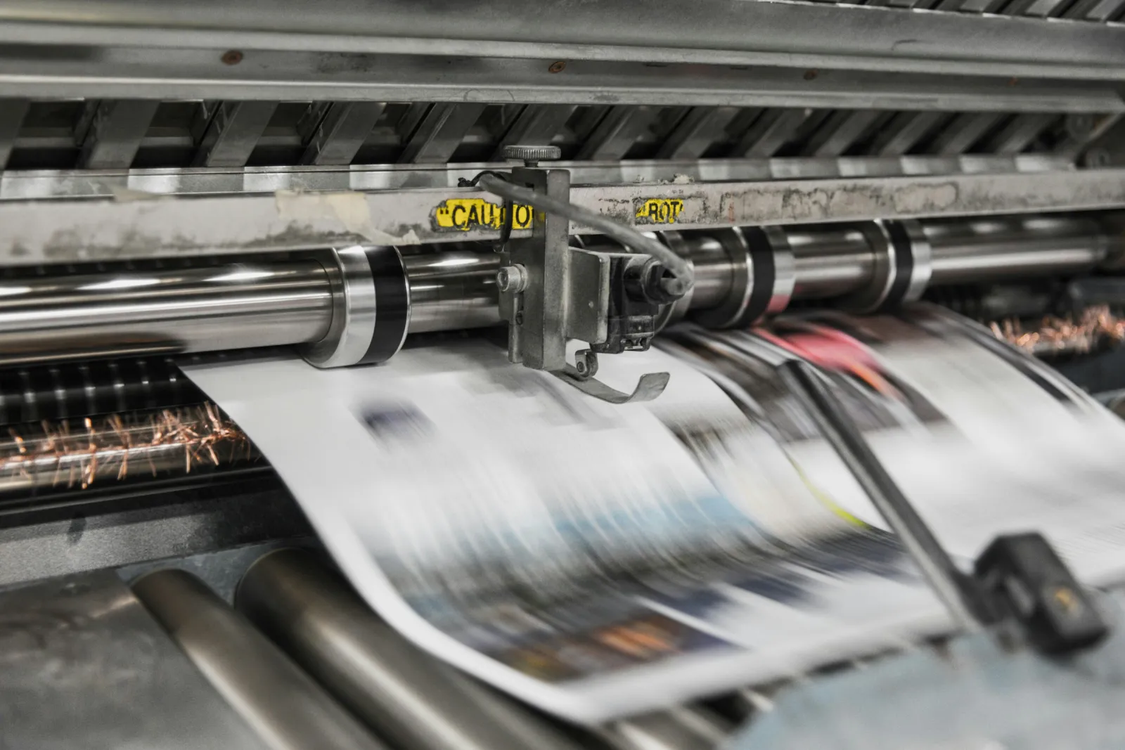 Freshly printed sheets feeding through an offset printing press