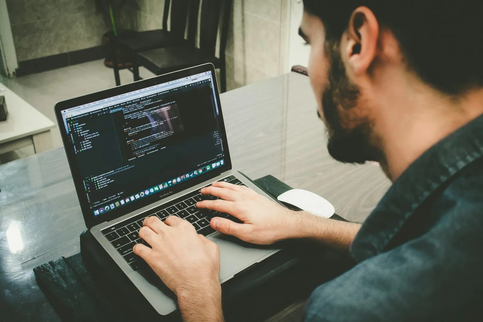 A developer writing code on a laptop